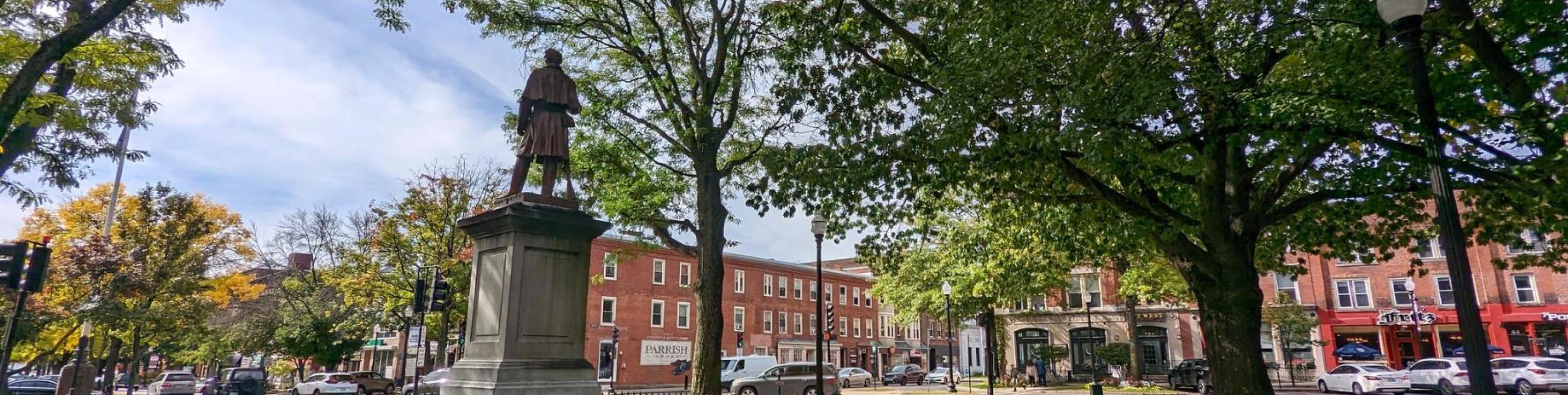 Downtown Keene Central Square Statue with Brick Buildings in Background