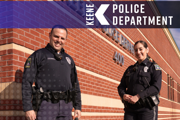 Two police officers in front of the Keene Police Department building