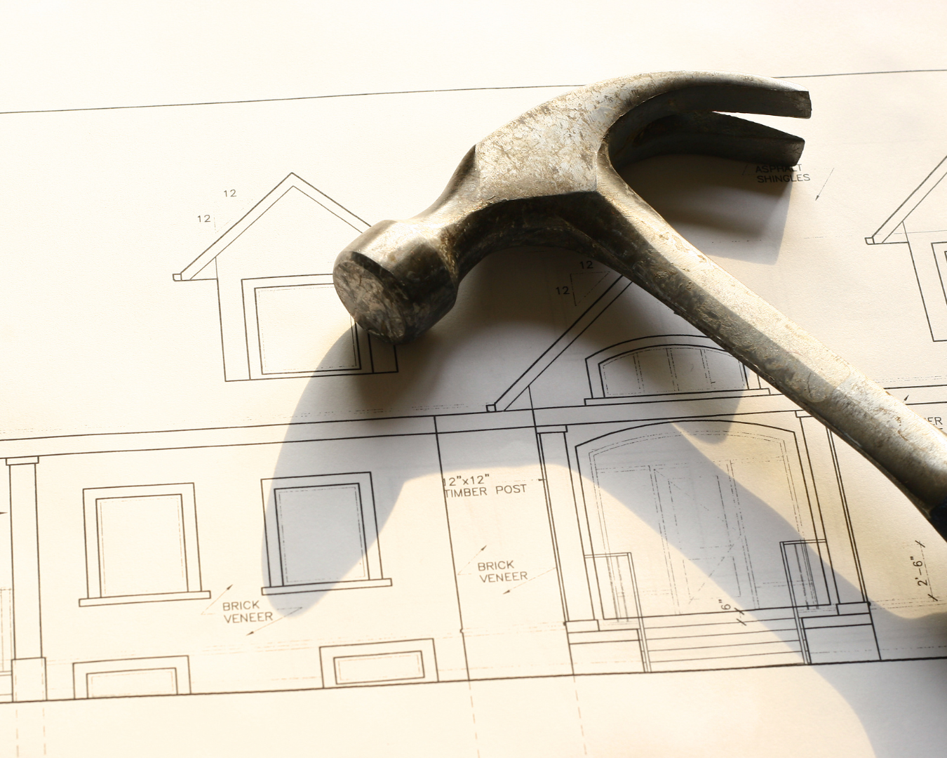 Blueprints of house with hammer