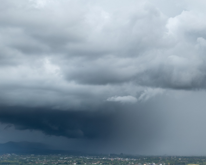 stormy clouds and rain over a town in the distance