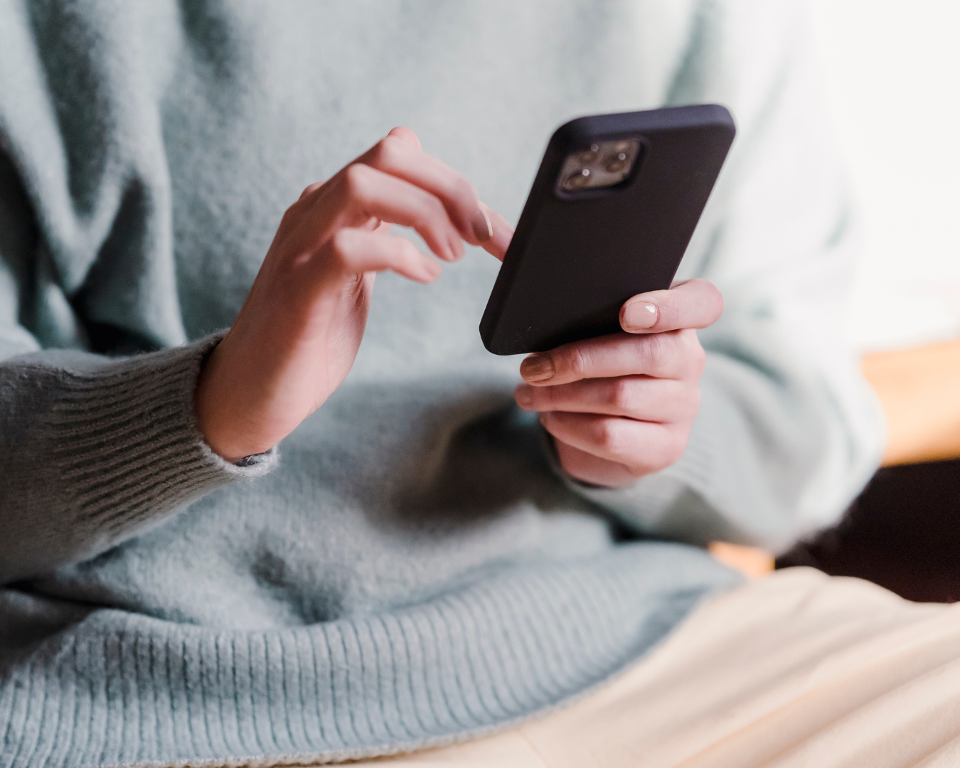 Close up on person's torso as they check their smart phone