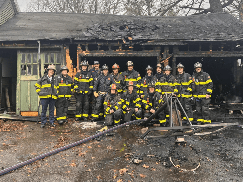 KFD crew stands outside a burnt building after they have extinguished the fire