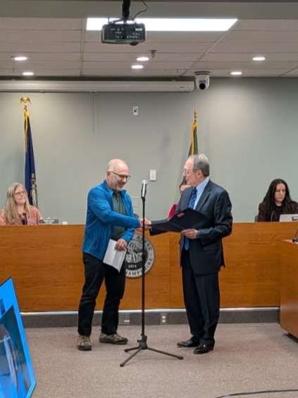 Mayor Kahn presenting the proclamation to Dwight Fischer. 