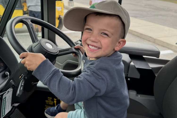 Smiling toddler sits in City vehicle